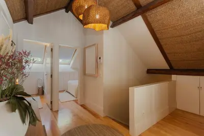 an attic room with white walls and wooden beams at The Terraced Loft - Boho Elegance in Porto in Porto