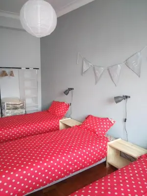 two beds in a room with red polka dot sheets at Lulapartment II in Porto