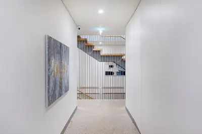 a hallway with white walls and stairs with paintings on the walls at Timeless Porto Studio @ Marquesa Palace in Porto