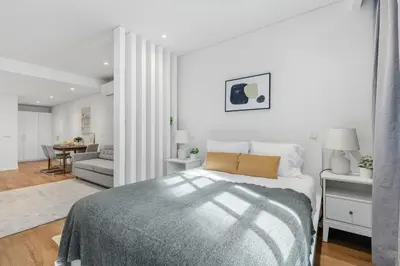a white bedroom with a bed and a living room at Timeless Porto Studio @ Marquesa Palace in Porto