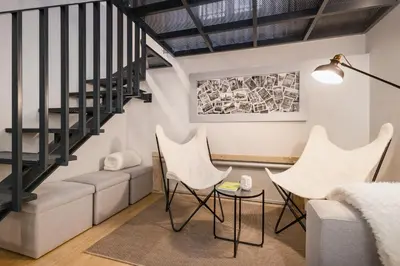 a black chair sitting in a room with a window at Ribeira Apartments São João in Porto