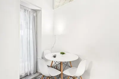 a white dining room with a white table and chairs at GuestReady - Charming Porto retreat in Porto