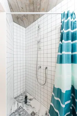 a bathroom with a shower with a blue and white shower curtain at GuestReady - Charming Porto retreat in Porto