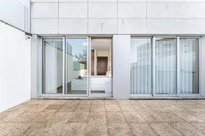 a facade of a white building with sliding glass doors at GuestReady - cosy retreat in Vila Nova de Gaia in Vila Nova de Gaia