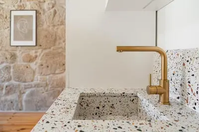 a kitchen sink with a gold faucet at Vila Rio Guest House in Vila Nova de Gaia