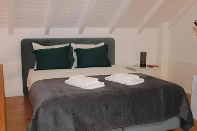 a bedroom with a large bed with green pillows at ALMADA LOFT LIVING by We Do Living in Porto