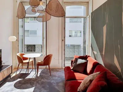 a living room with a red couch and a table at Classic loft in fully renewed building at Batalha in Porto