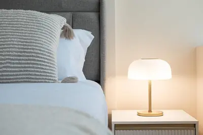a bed with a white pillow and a lamp on a table at GuestReady - Marble Branch in Porto