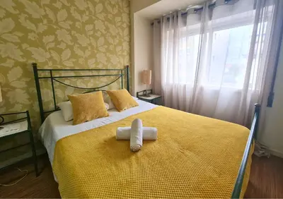 a bedroom with a yellow bed with a towel on it at D Joao Premium Suite Bolhao Metro in Porto