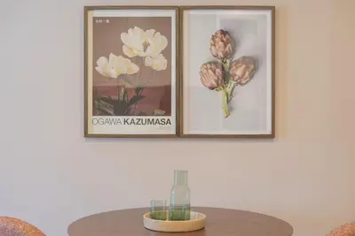 a table with two pictures of flowers on a wall at Uma Poveiros in Porto