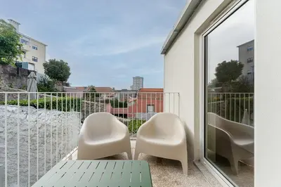 a balcony with two chairs and a table and a window at Modern 1BR Apartment - Brand New Bonjardim I in Porto