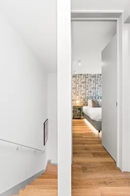 a bedroom and a living room with white walls and a bed at Stay Bonjardim - Modern Garden Duplex M in Porto