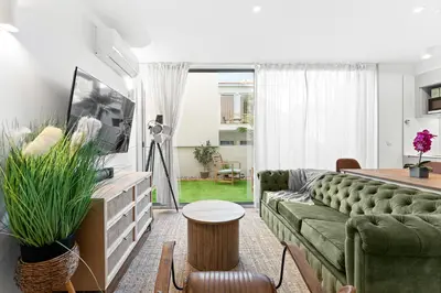 a living room with a green couch and a table at Stay Bonjardim - Modern Garden Duplex M in Porto