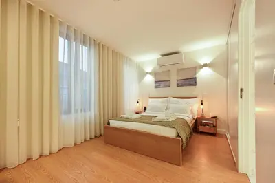 a white bedroom with a bed and a table and chairs at ON Apartments - MA62 Downtown in Porto