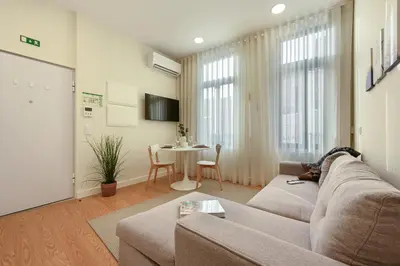 a kitchen with white cabinets and a small table at ON Apartments - MA62 Downtown in Porto