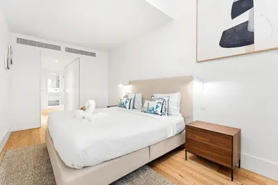 a white bedroom with a large bed and a wooden table at Unique Luxury and Quiet in Porto Best Location in Porto