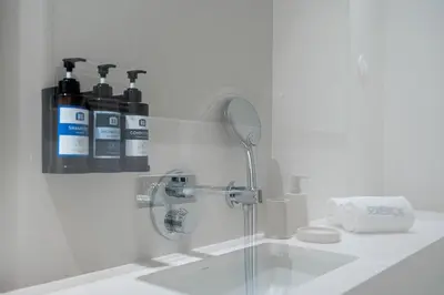 a bathroom with a sink with two bottles on the wall at Unique Luxury and Quiet in Porto Best Location in Porto