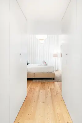 a white bedroom with a bed and a wooden floor at Unique Luxury and Quiet in Porto Best Location in Porto
