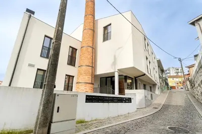 an empty street in front of a building with two chimneys at GuestReady - comfort near Jardim do Morro in Vila Nova de Gaia