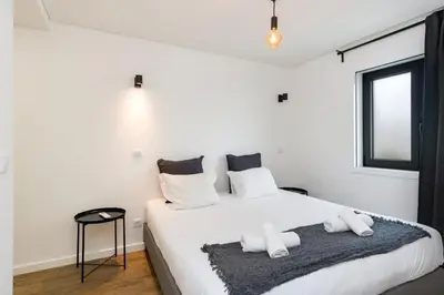 a white bedroom with a bed with white pillows at GuestReady - comfort near Jardim do Morro in Vila Nova de Gaia