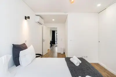 a bedroom with a white bed and white walls at GuestReady - comfort near Jardim do Morro in Vila Nova de Gaia
