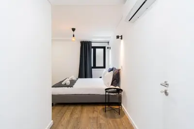 a bedroom with a bed in a white room at GuestReady - comfort near Jardim do Morro in Vila Nova de Gaia