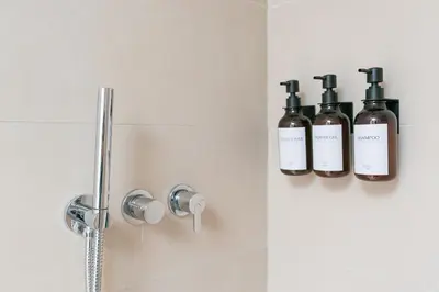 a bathroom with three bottles of soap on a wall at Stay Bonjardim - Modern Garden Duplex N in Porto