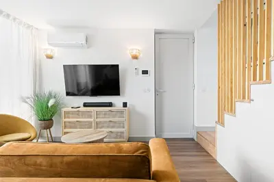 a living room with a couch and a tv at Stay Bonjardim - Modern Garden Duplex N in Porto