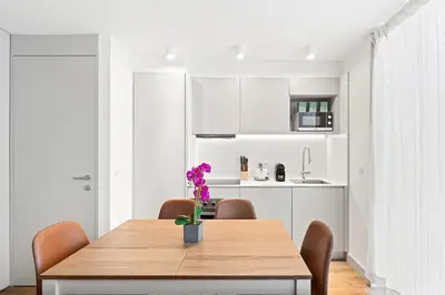 a dining room with a table with purple flowers on it at Stay Bonjardim - Modern Garden Duplex N in Porto