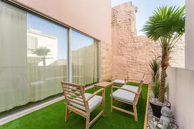 a patio with two chairs and a table and some plants at Stay Bonjardim - Modern Garden Duplex N in Porto