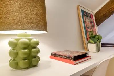 a green lamp sitting on a table with books at Duque 3 Luxury Apartment Downtown Porto near Metro in Porto