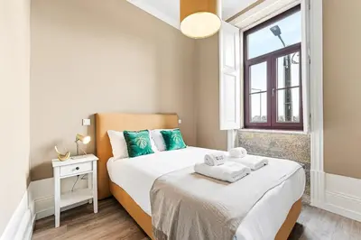 a small bedroom with two beds and a window at GuestReady - Charming Gaia apartment in Vila Nova de Gaia