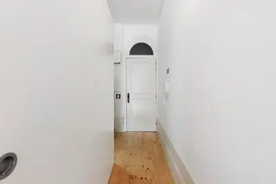 a hallway with a white door and a wooden floor at Breiner House Porto in Porto