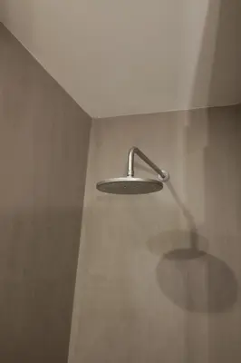 a shower with a shower head on a wall at Modern Flat with balcony on Rua das Flores - 2nd in Porto