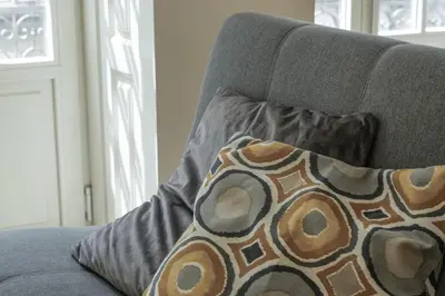 a gray couch with a pillow on it at Modern Flat with balcony on Rua das Flores - 2nd in Porto