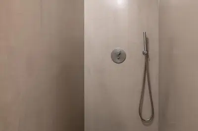 a shower with a hose attached to a white wall at Modern Flat with balcony on Rua das Flores - 3rd in Porto