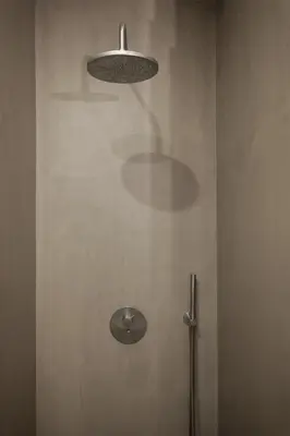 a bathroom with a shower with a light on the wall at Modern Flat on Rua das Flores - 4th Floor in Porto