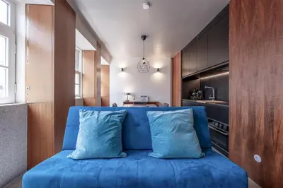 a blue couch in a room with a kitchen at Modern Flat on Rua das Flores - 4th Floor in Porto