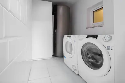a washer and dryer in a white laundry room at NEW! House with Hot Tub by Douro River & Iconic Bridge in Vila Nova de Gaia