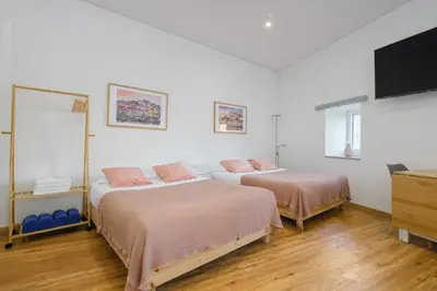 a bedroom with two beds and a flat screen tv at NEW! House with Hot Tub by Douro River & Iconic Bridge in Vila Nova de Gaia