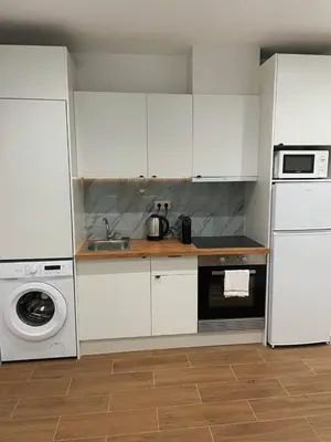 a kitchen with white cabinets and a washing machine at Bandeira Place in Porto