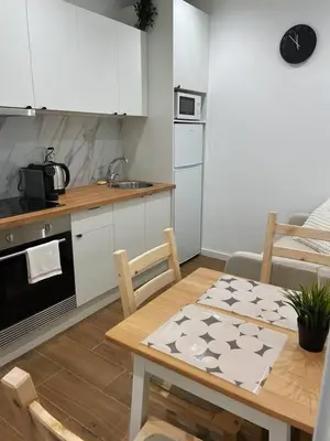 a kitchen with a wooden table and a kitchen with white cabinets at Bandeira Place in Porto