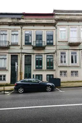 a black car parked in a parking lot in front of a building at Bright Cedofeita Flat with Balcony in Porto
