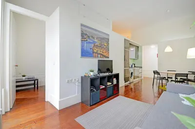 a living room with a television and a dining room at Bright Cedofeita Flat with Balcony in Porto