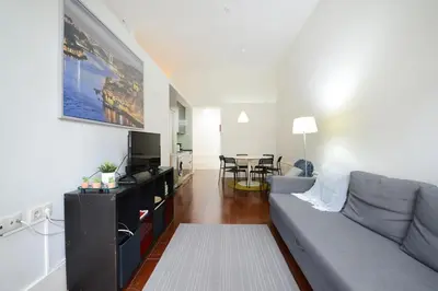 a living room with a couch and a tv at Bright Cedofeita Flat with Balcony in Porto