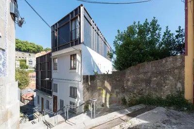 a white building with a tall building behind it at Casa Panorama | Douro Views in Porto