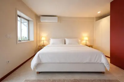 a bedroom with a large white bed with two lamps at Good View Studio in Porto