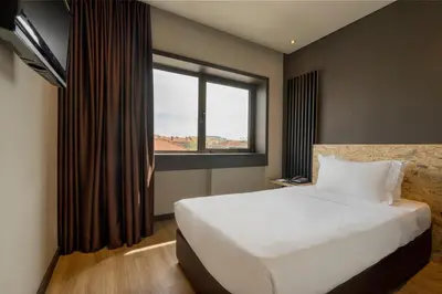 a bedroom with a large white bed and a window at HF Ala Sul in Porto