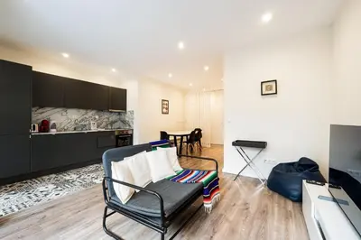 a living room with a chair and a kitchen at GuestReady - Cosy family home in the Bonfim area in Porto