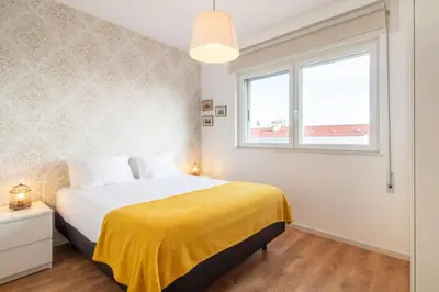 a bedroom with a bed with a yellow blanket and a window at Violet House by LovelyStay in Vila Nova de Gaia